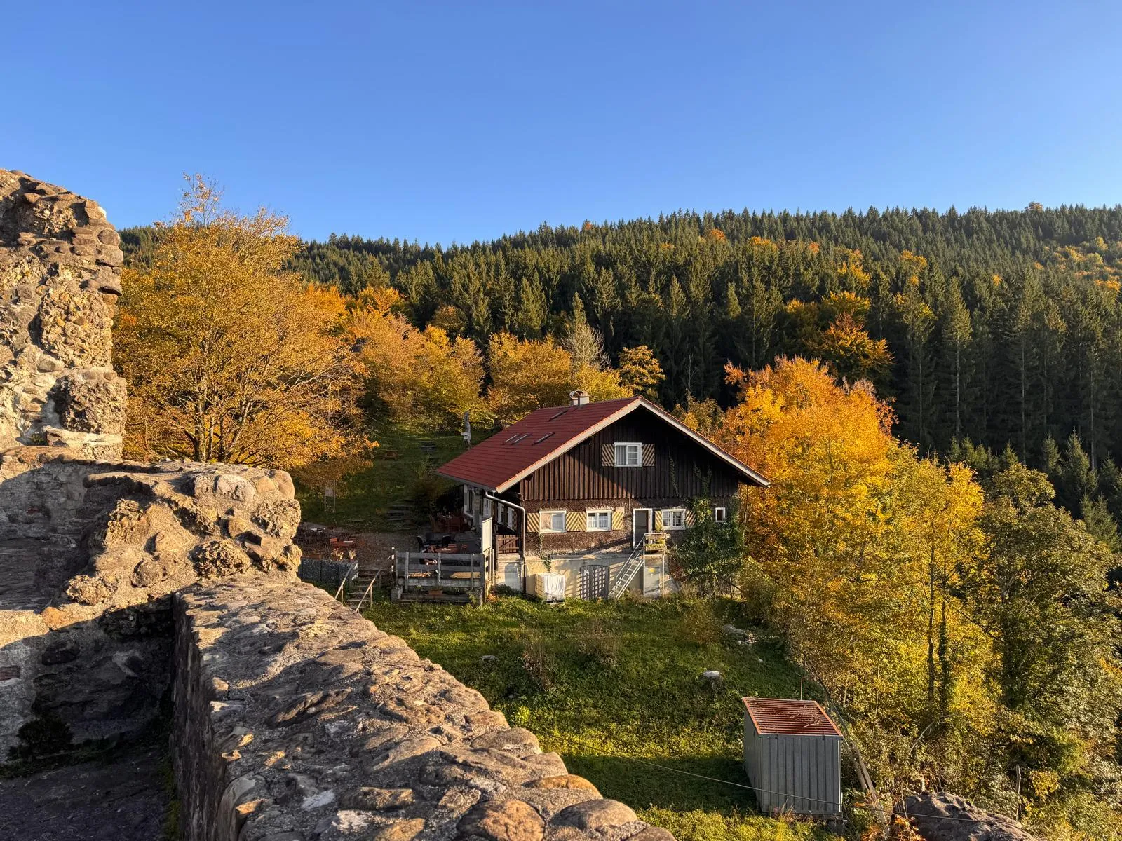 Burggaststätte Alttrauchburg im Sommer mit Gästen im Biergarten